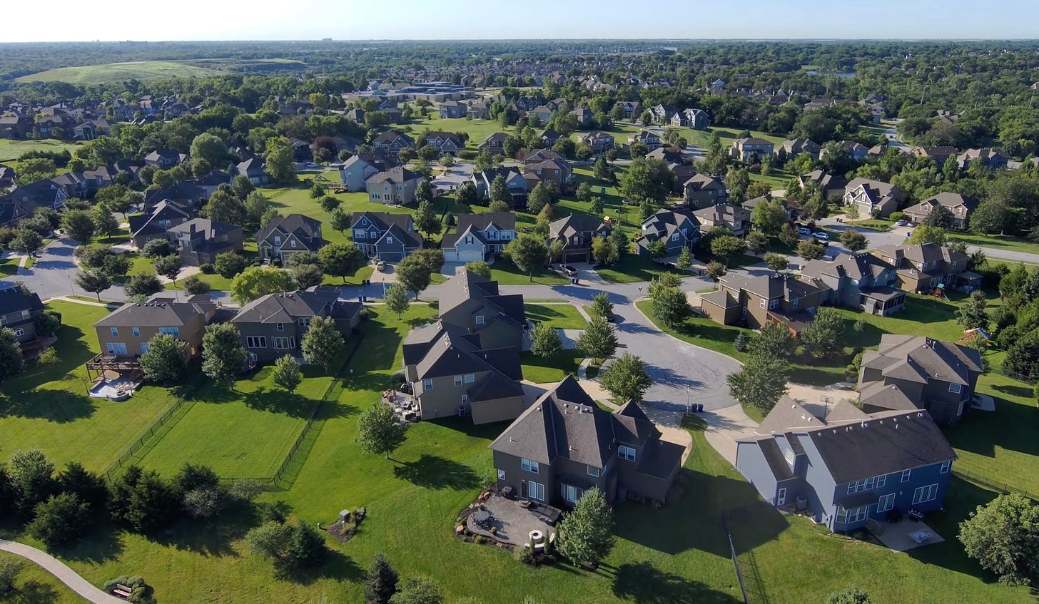 Image: American Suburb - Image from video by David McBee - [pexels.com](https://www.pexels.com/video/drone-footage-of-a-neighborhood-5031099/)